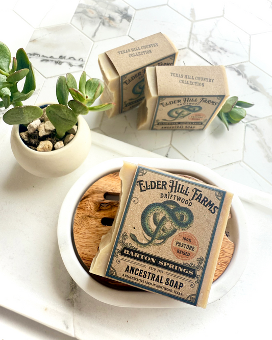 Elder Hill Farms soap bars on a white surface with a small plant.